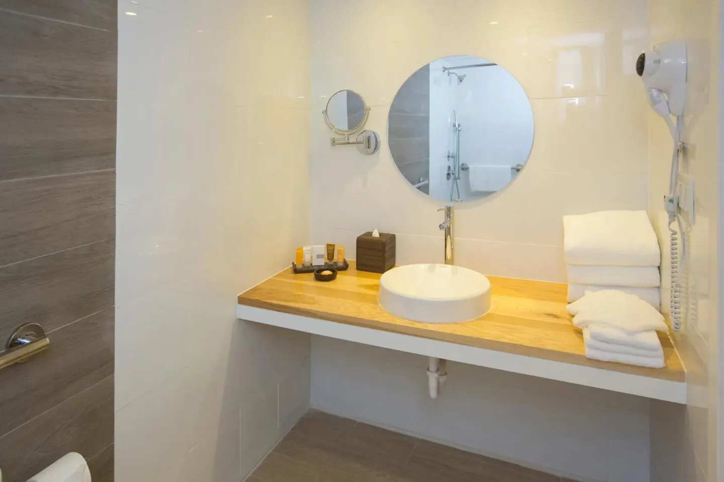 Water View bathroom vanity with round mirror and towels at Warwick Paradise Island.