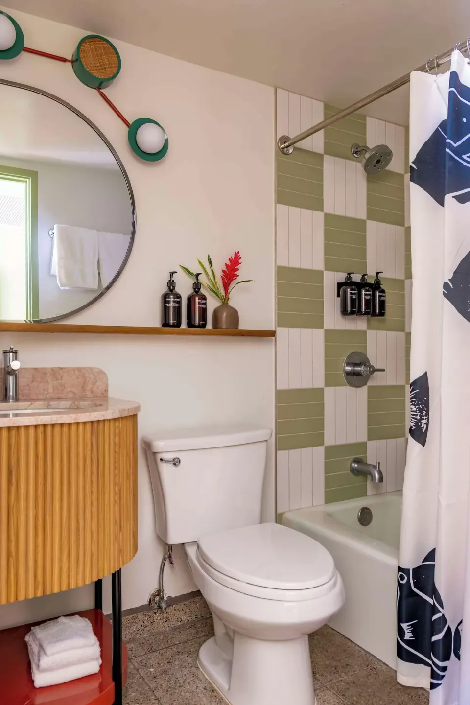 Guest bathroom with striped tile shower, tub, toilet, and vanity at Wayfinder Waikiki.