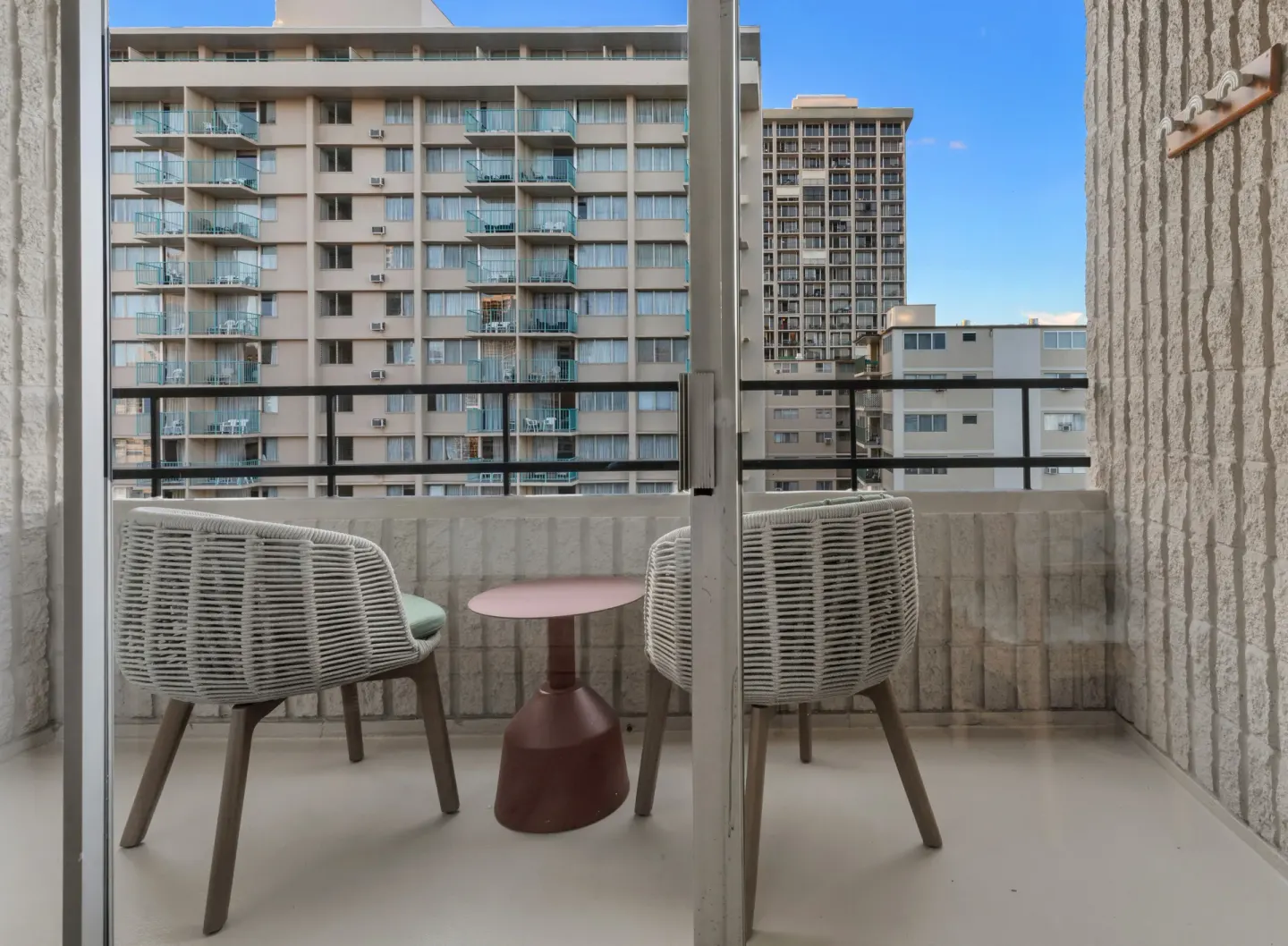 Balcony seating facing neighboring apartment buildings at Wayfinder Waikiki.