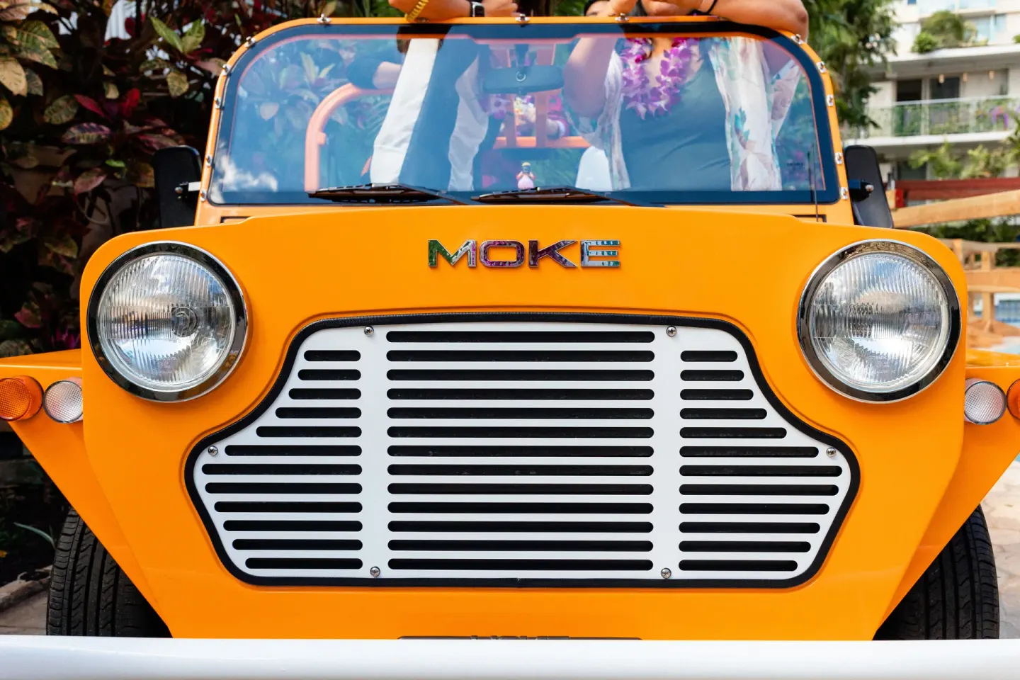 Bright orange open-air resort vehicle parked outside Wayfinder Waikiki.