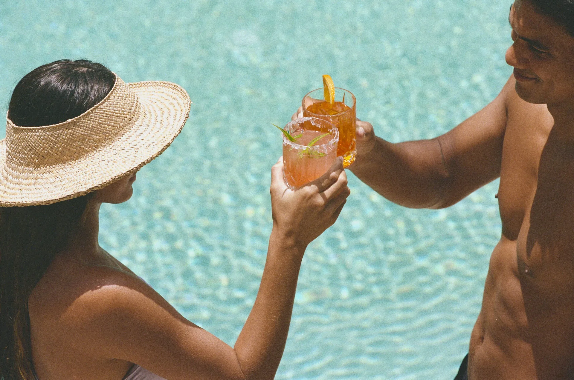 Two guests toast cocktails in the pool at Wayfinder Waikiki.