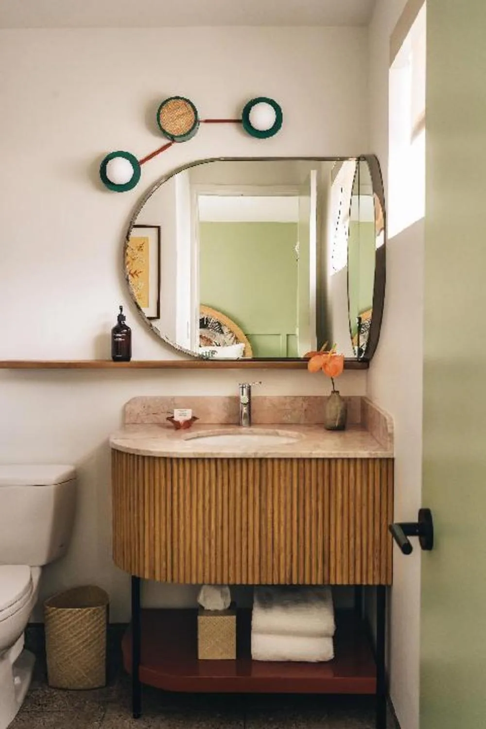 Accessible Bed with Lanai bathroom at Wayfinder Waikiki with wood vanity, mirror, sink, and toilet.