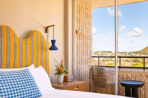 One Bedroom Penthouse Suite king bed by balcony doors at Wayfinder Waikiki.