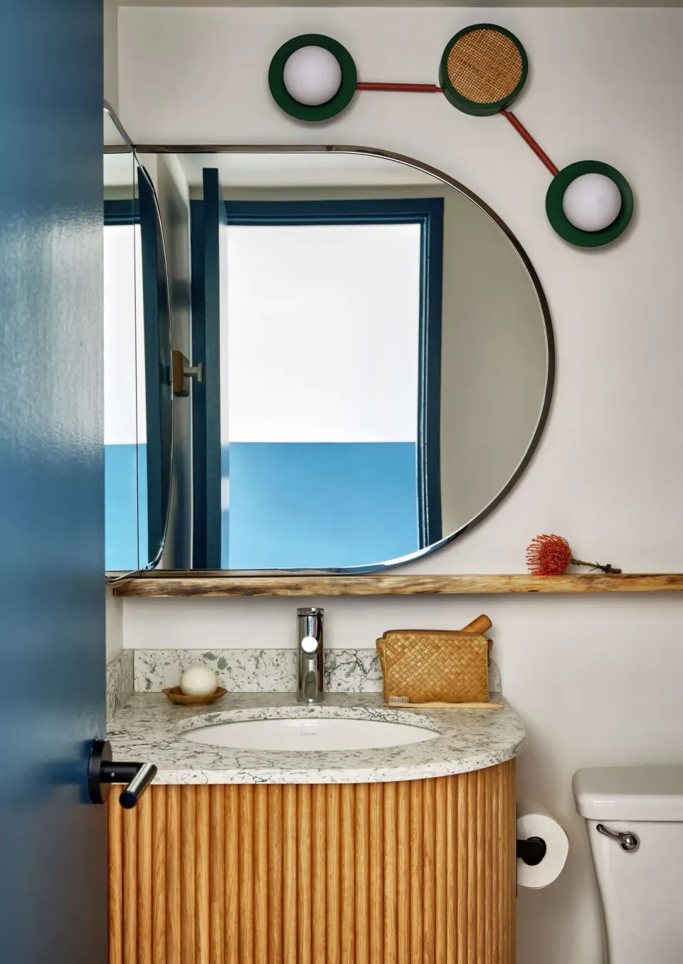 Premium Room bathroom vanity with round mirror and cane details at Wayfinder Waikiki.