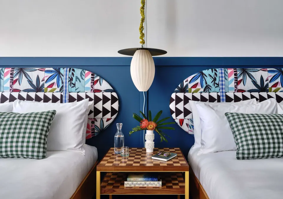 Premium Room two beds with pendant light and center nightstand at Wayfinder Waikiki.