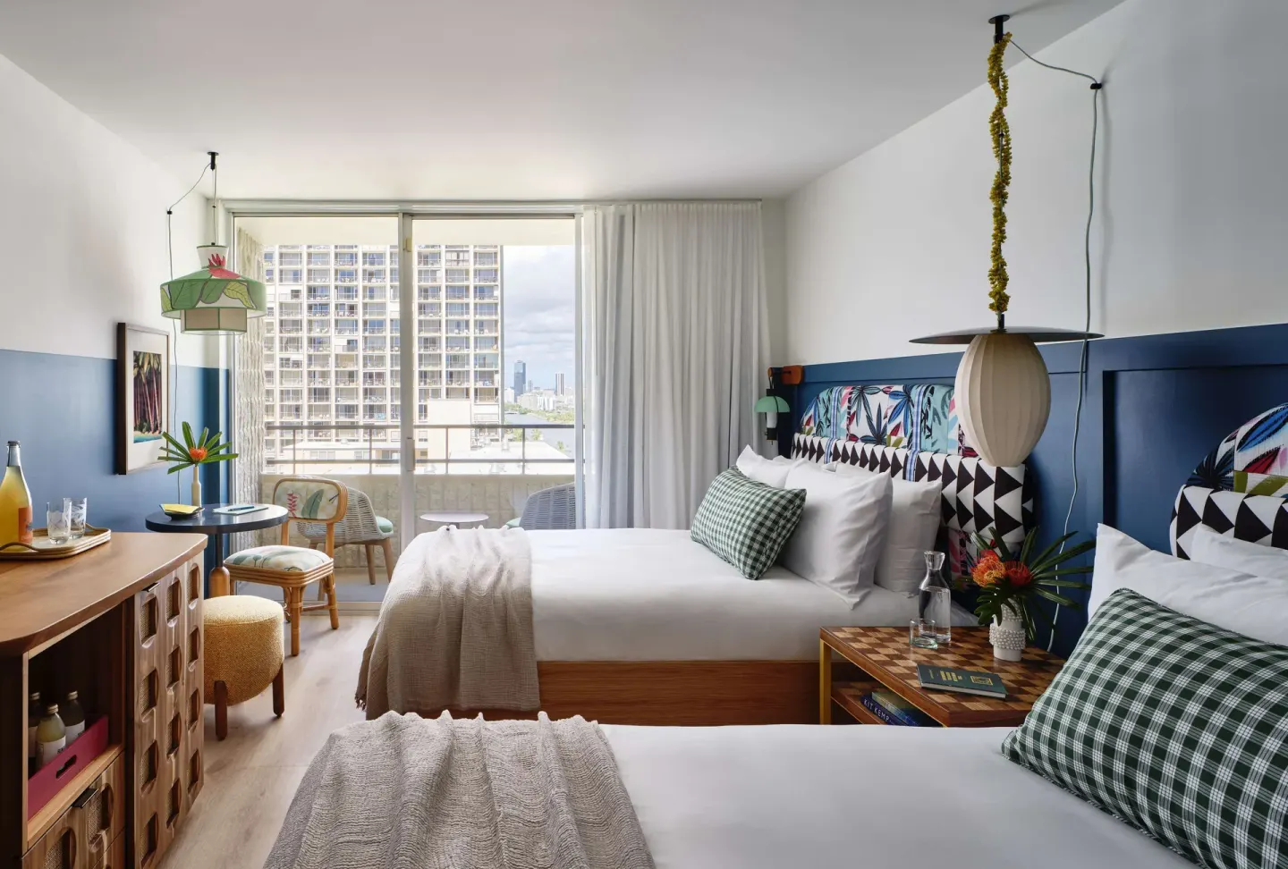 Premium Room with two beds, balcony doors, and city view at Wayfinder Waikiki.