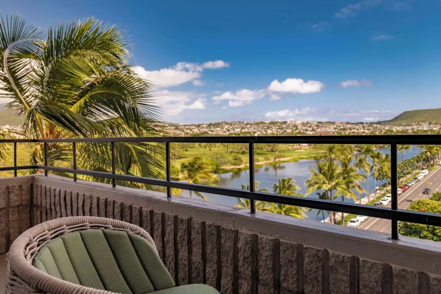 Premium Room balcony view with palms, canal, and mountains at Wayfinder Waikiki.