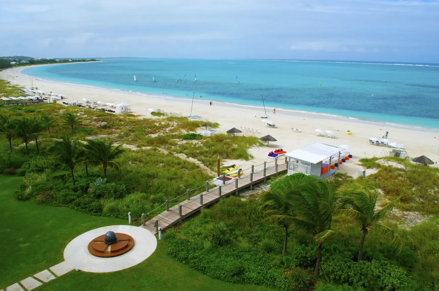 Elevated beach view with dunes, boardwalk, and turquoise water at West Bay Club.
