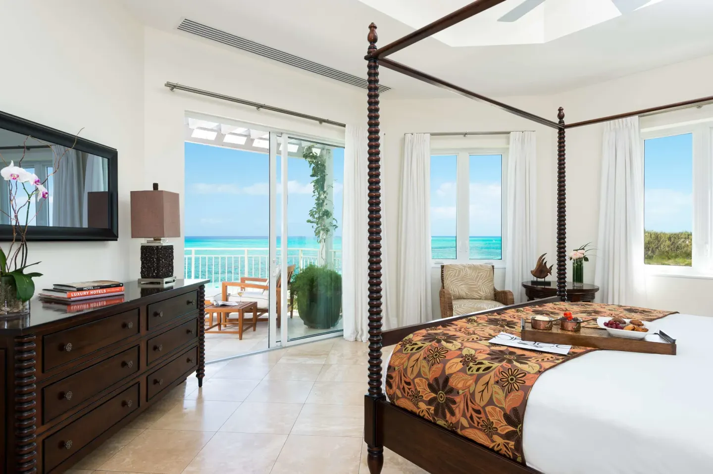 Four-poster king bedroom with balcony and ocean view at West Bay Club.