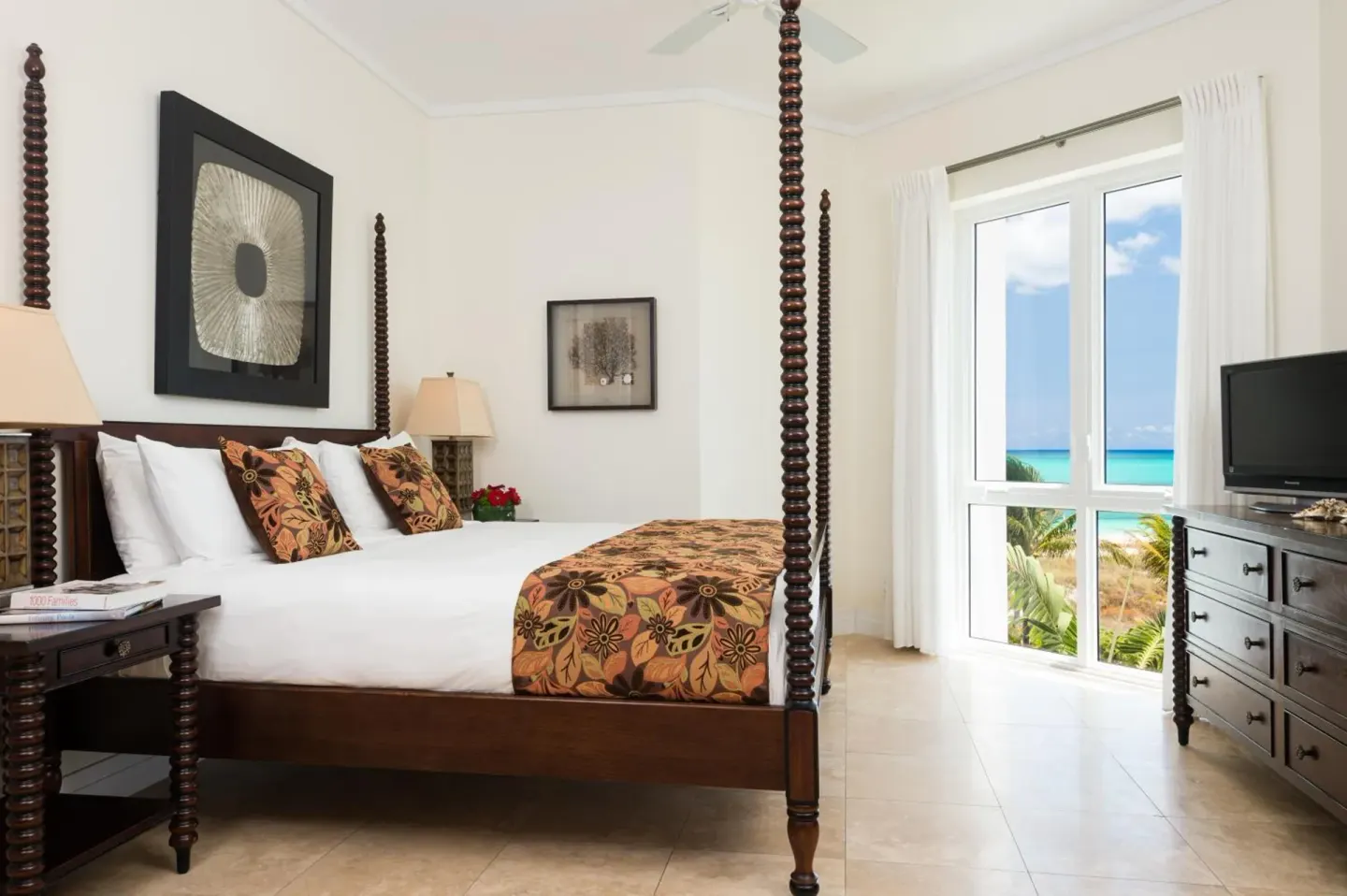 Four-poster king bedroom with ocean-view window at West Bay Club.
