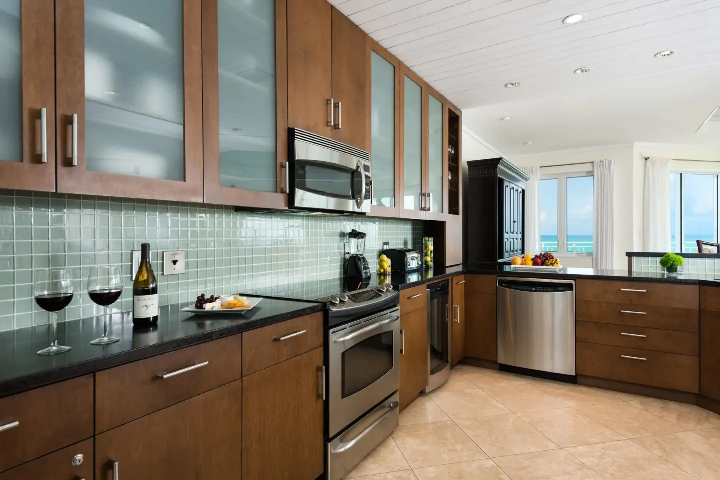 Suite kitchen with wood cabinets, appliances, and ocean view at West Bay Club.
