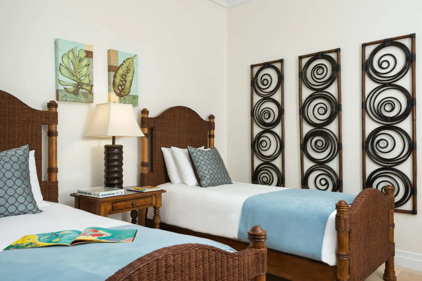 Twin bedroom with wicker beds and wall art at West Bay Club.