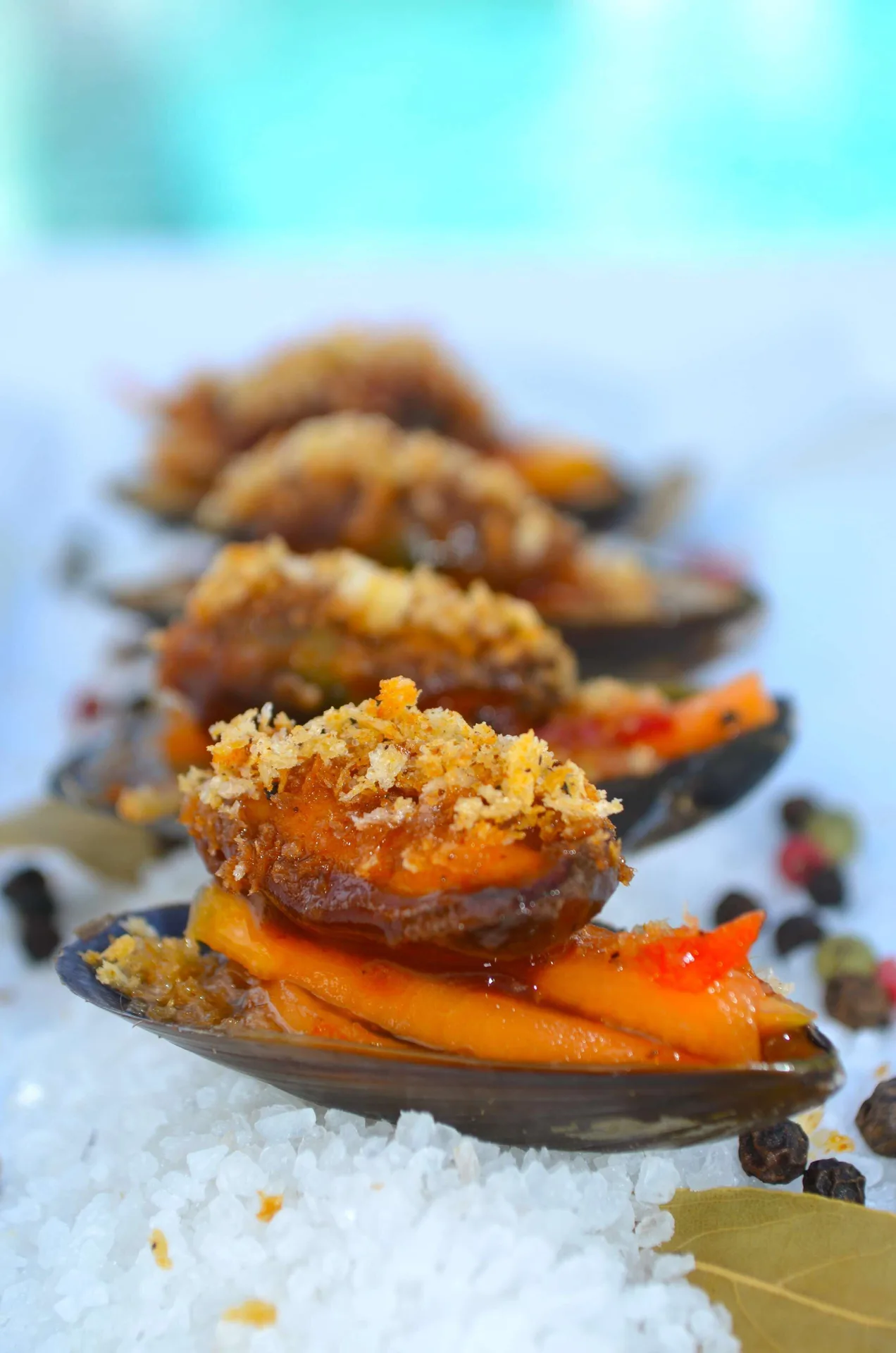 Seasoned mussels are arranged on salt with spices at West Bay Club.