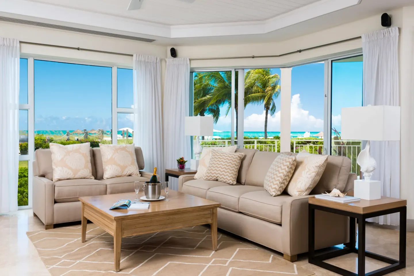 Oceanfront living room in a Luxury Suite at West Bay Club with sofas and wide windows.