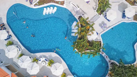 Aerial view of connected resort pools with loungers at Windjammer Landing Resort and Residences.
