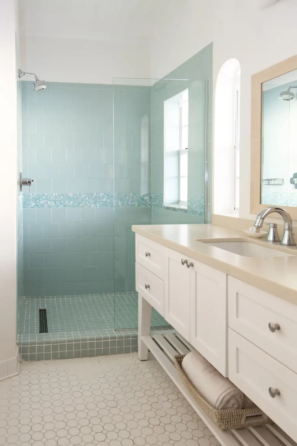 Bathroom with aqua tiled walk-in shower and white vanity at Windjammer Landing Resort and Residences.