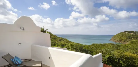 Private terrace with lounge chair, outdoor shower and bay view at Windjammer Landing Resort and Residences.