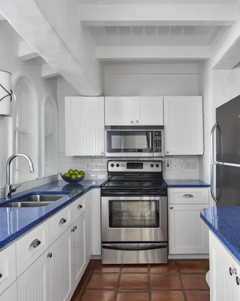 White guest room kitchen with blue counters at Windjammer Landing Resort and Residences.