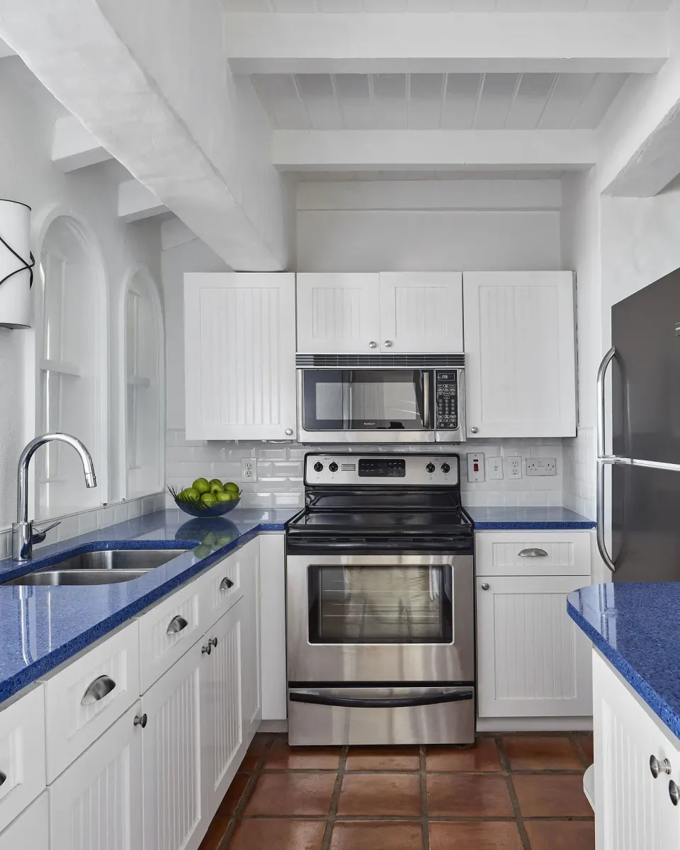 White guest room kitchen with blue counters at Windjammer Landing Resort and Residences.