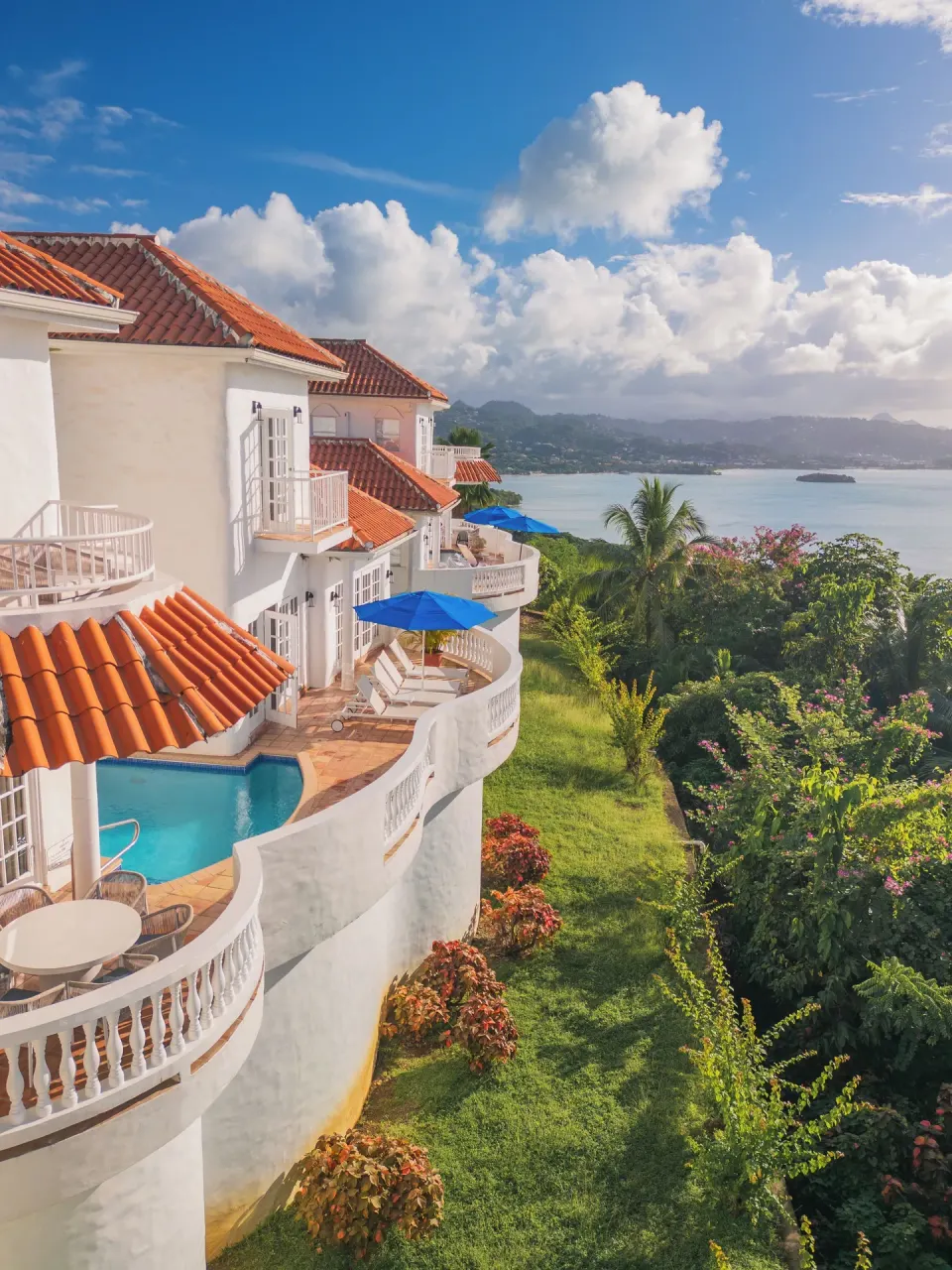 Hillside villas with red tile roofs, terraces and plunge pool at Windjammer Landing Resort and Residences.