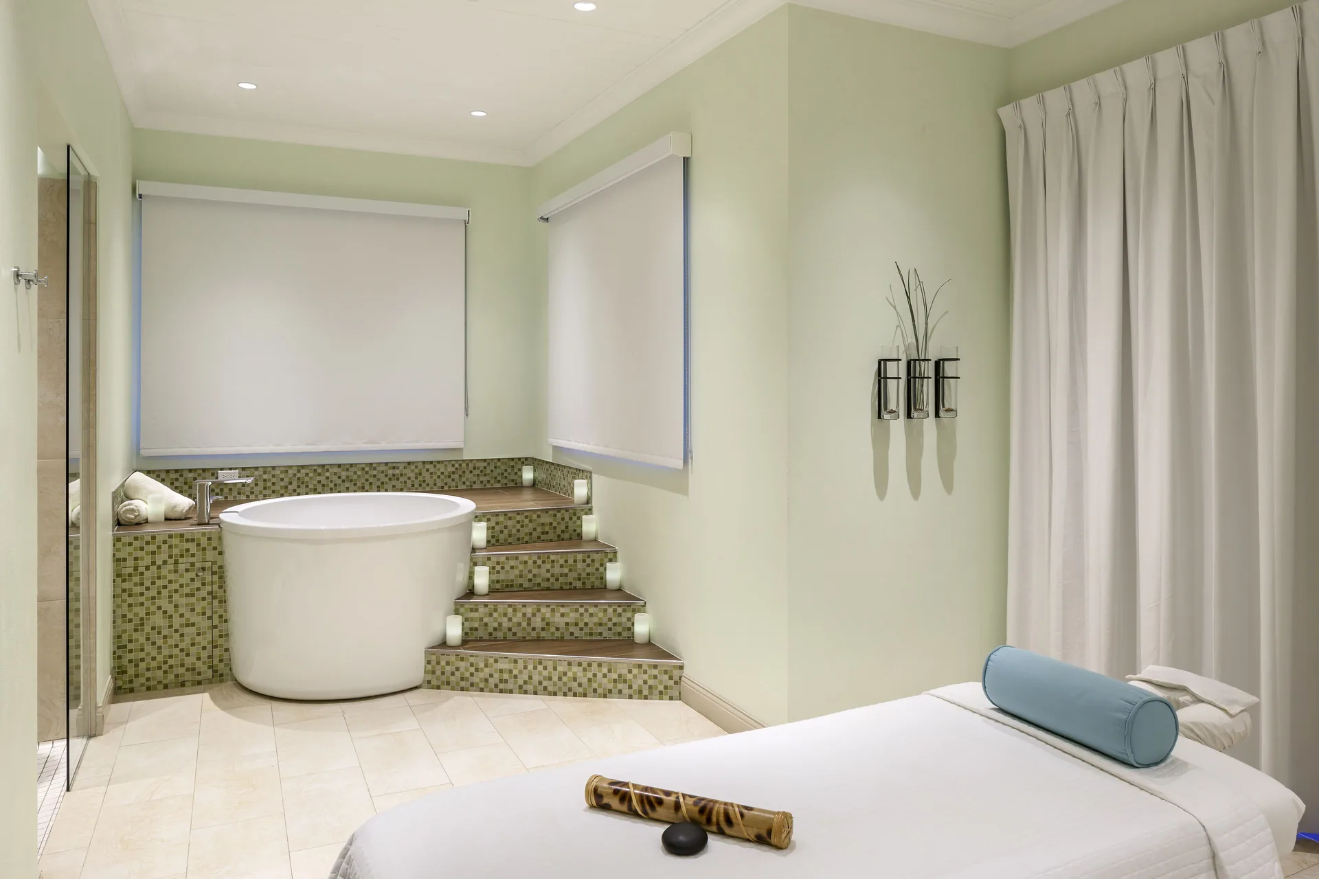 A spa treatment room with a massage table and soaking tub at Windjammer Landing Resort and Residences.
