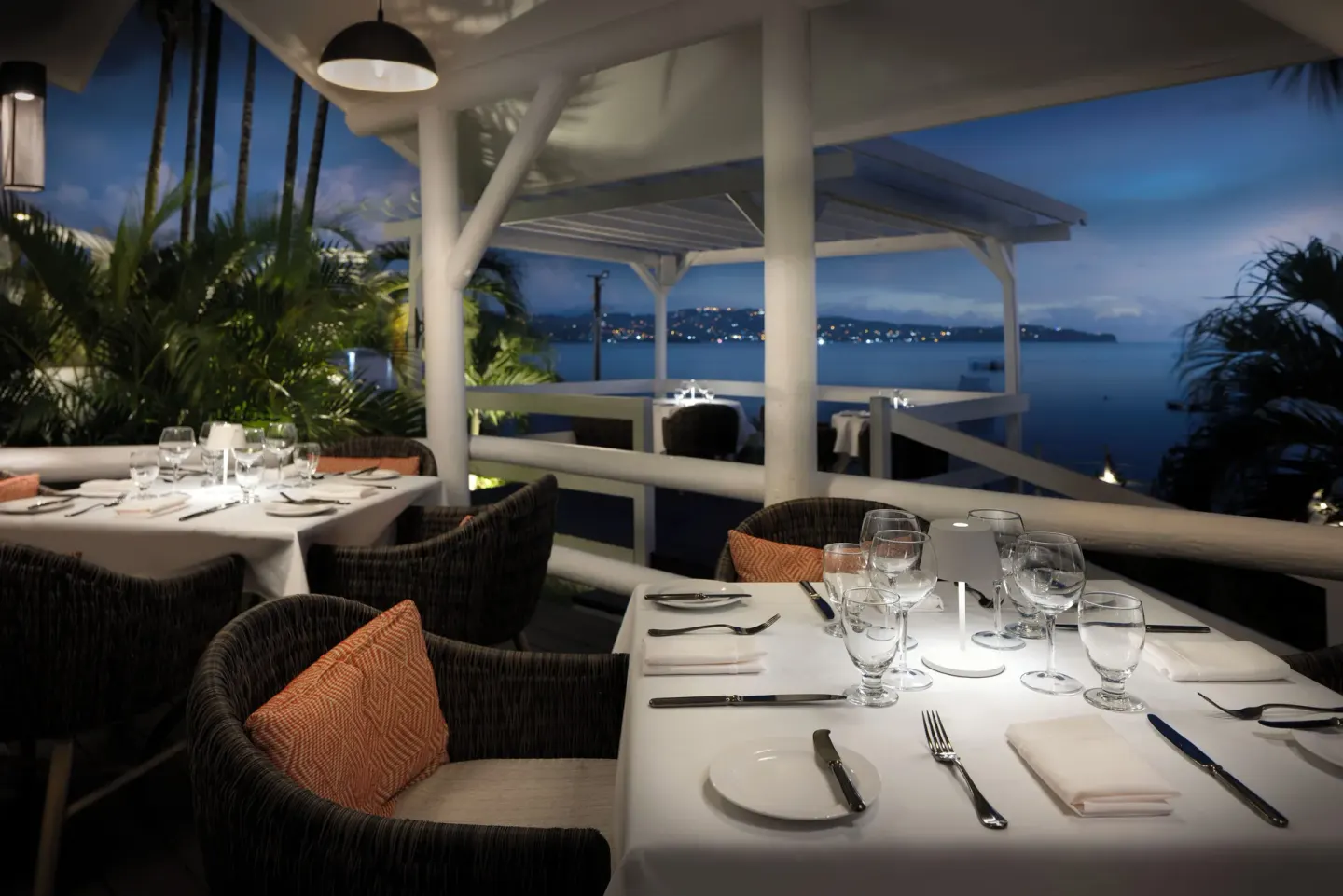 Terrace dining tables overlook the bay at Windjammer Landing Resort and Residences.