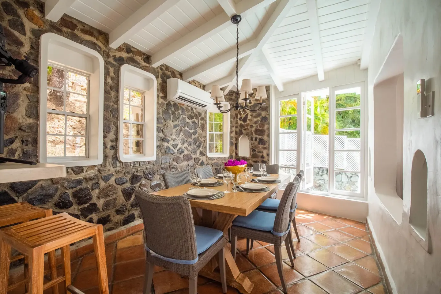 Stone-walled dining room with a set table at Windjammer Landing Resort and Residences.
