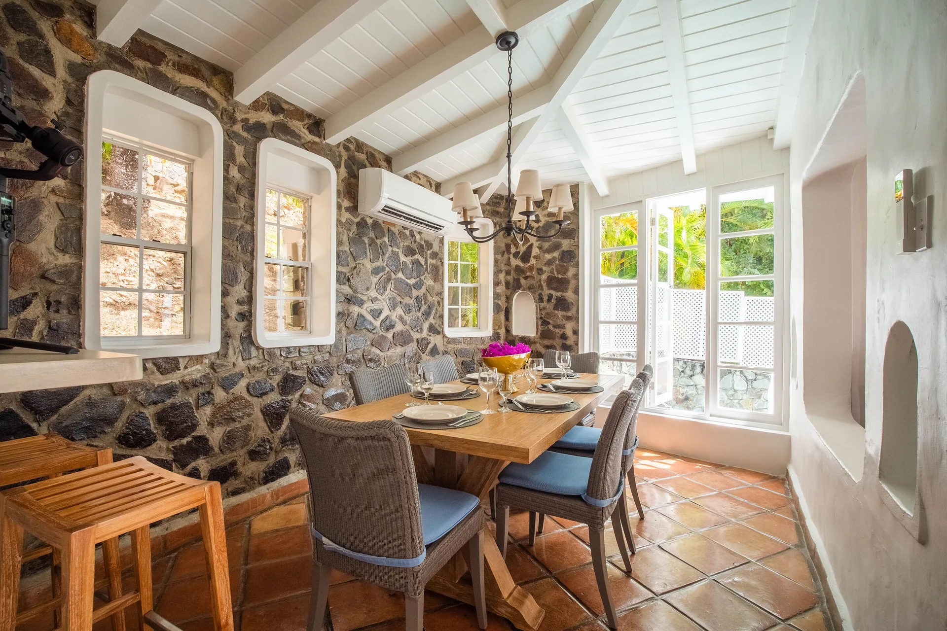 Stone-walled dining room with a set table at Windjammer Landing Resort and Residences.