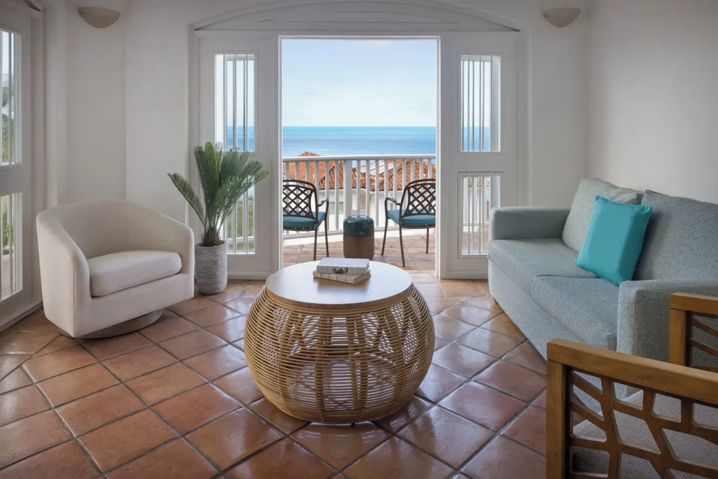 Living room in a four-bedroom hilltop villa at Windjammer Landing Resort and Residences with balcony sea view.