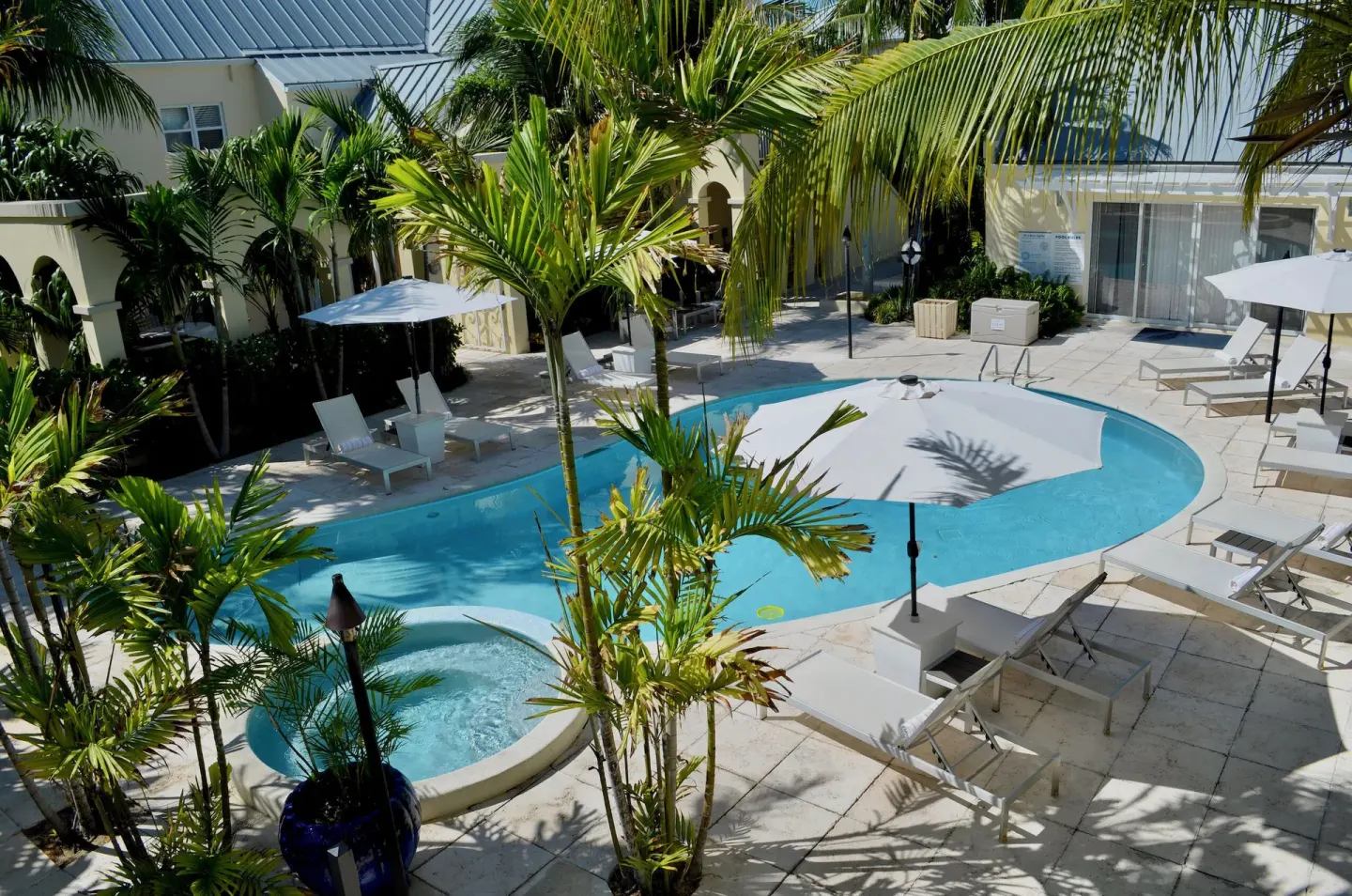 Courtyard pool with loungers and palms at Windsong on the Reef.