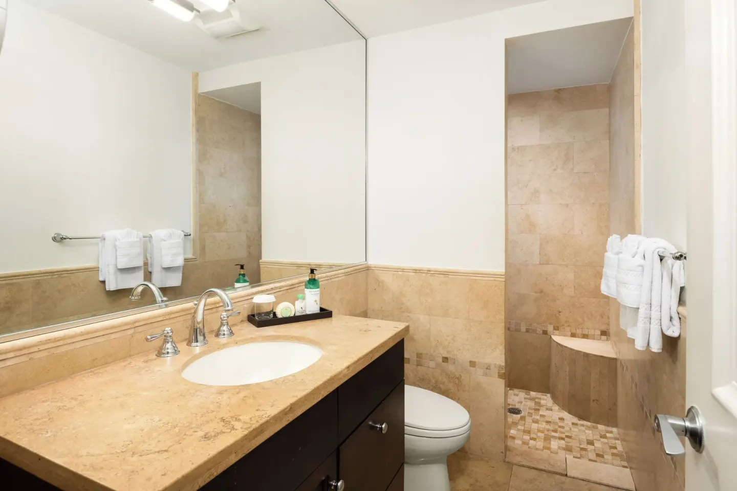 Bathroom with stone vanity and tiled shower at Windsong on the Reef.