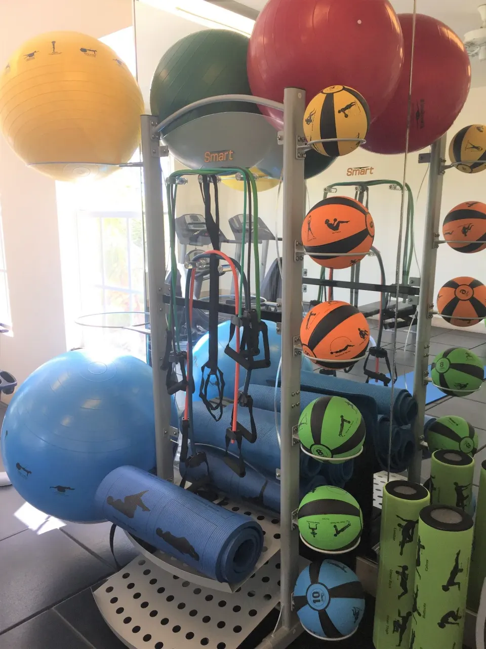 Fitness balls, mats, and medicine balls on a rack in the gym at Windsong on the Reef.