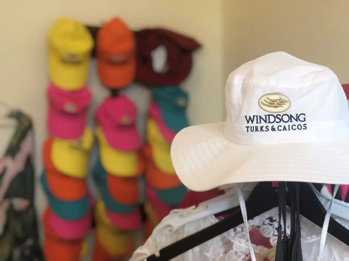 Logo sun hat and colorful caps displayed in the shop at Windsong on the Reef.