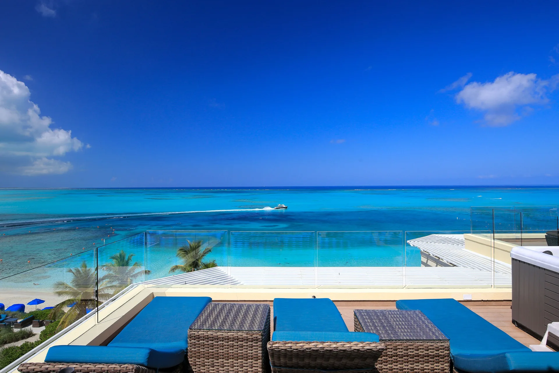 Rooftop lounge chairs overlooking turquoise reef water at Windsong on the Reef.