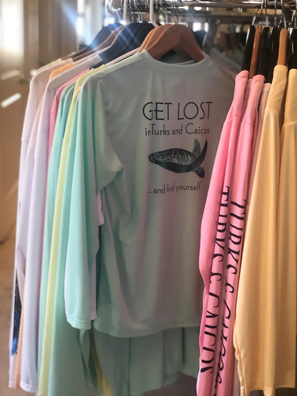 Colorful souvenir shirts hang on a rack at Windsong on the Reef.