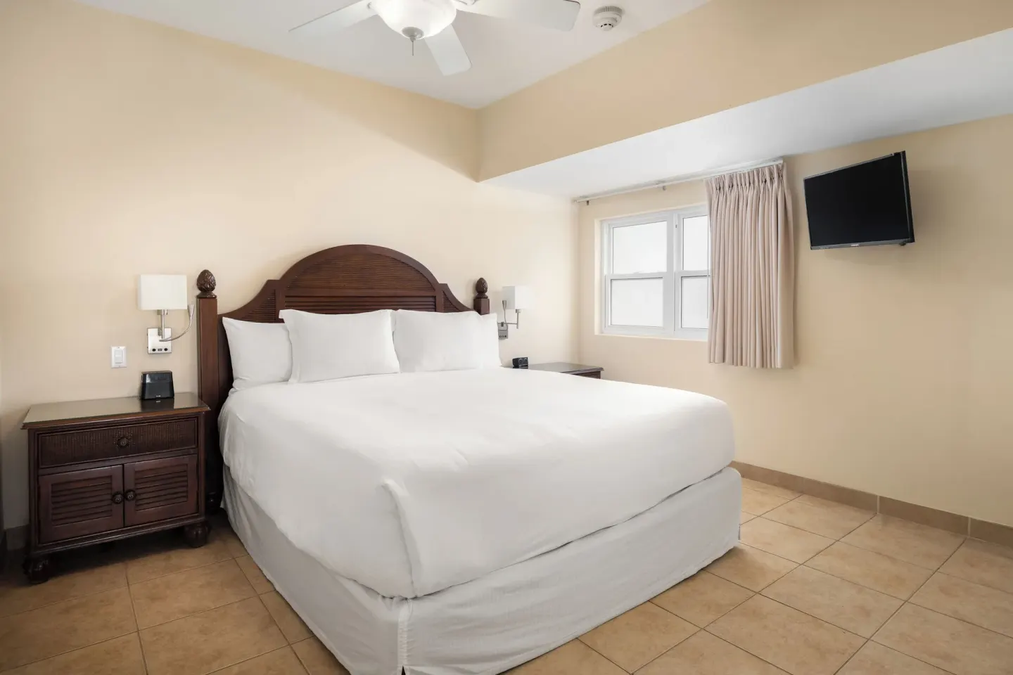 King bed with white linens in a Bungalow 1 Bedroom at Windsong on the Reef.