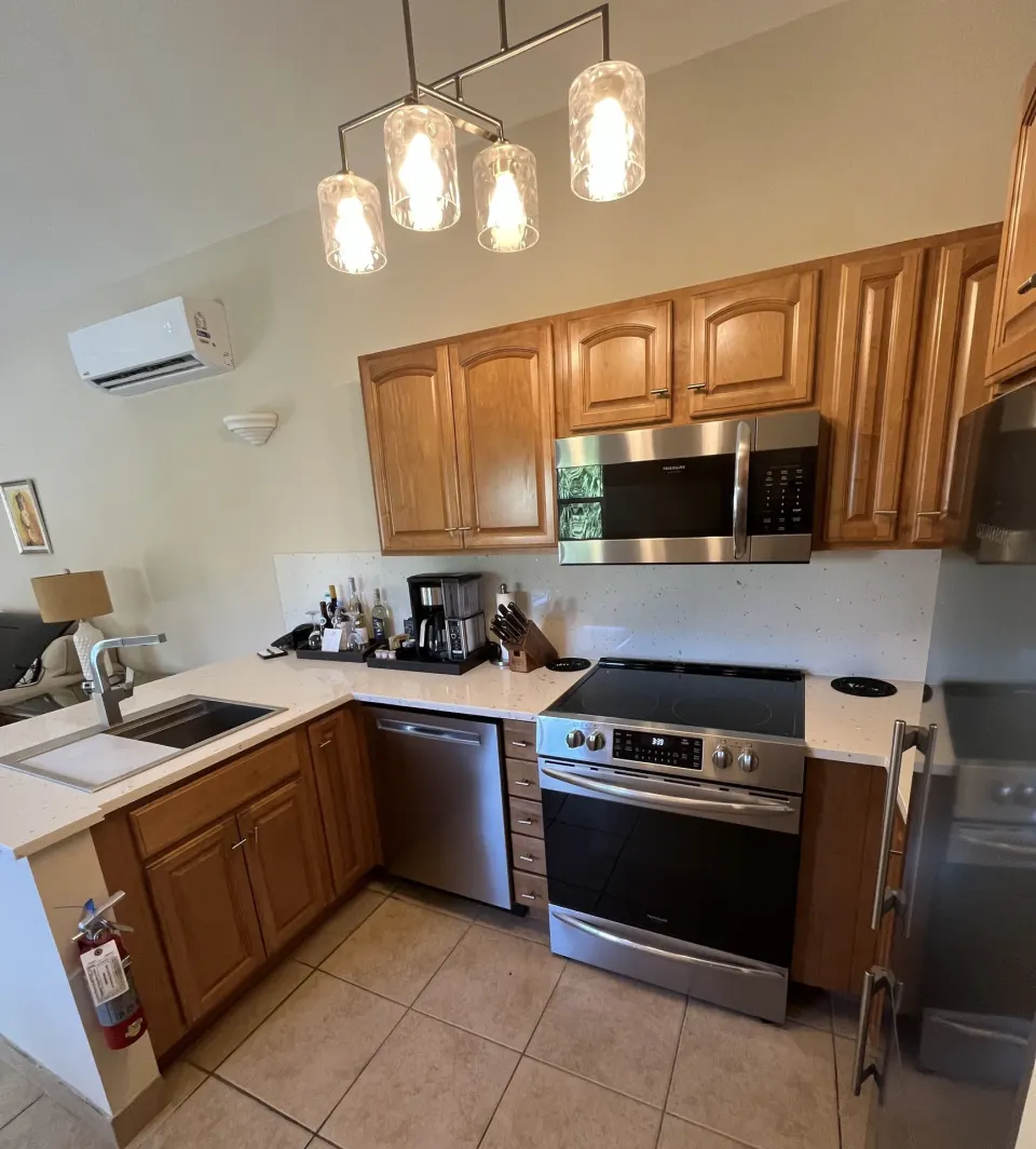 Kitchen with wood cabinets in a Bungalow 1 Bedroom at Windsong on the Reef.