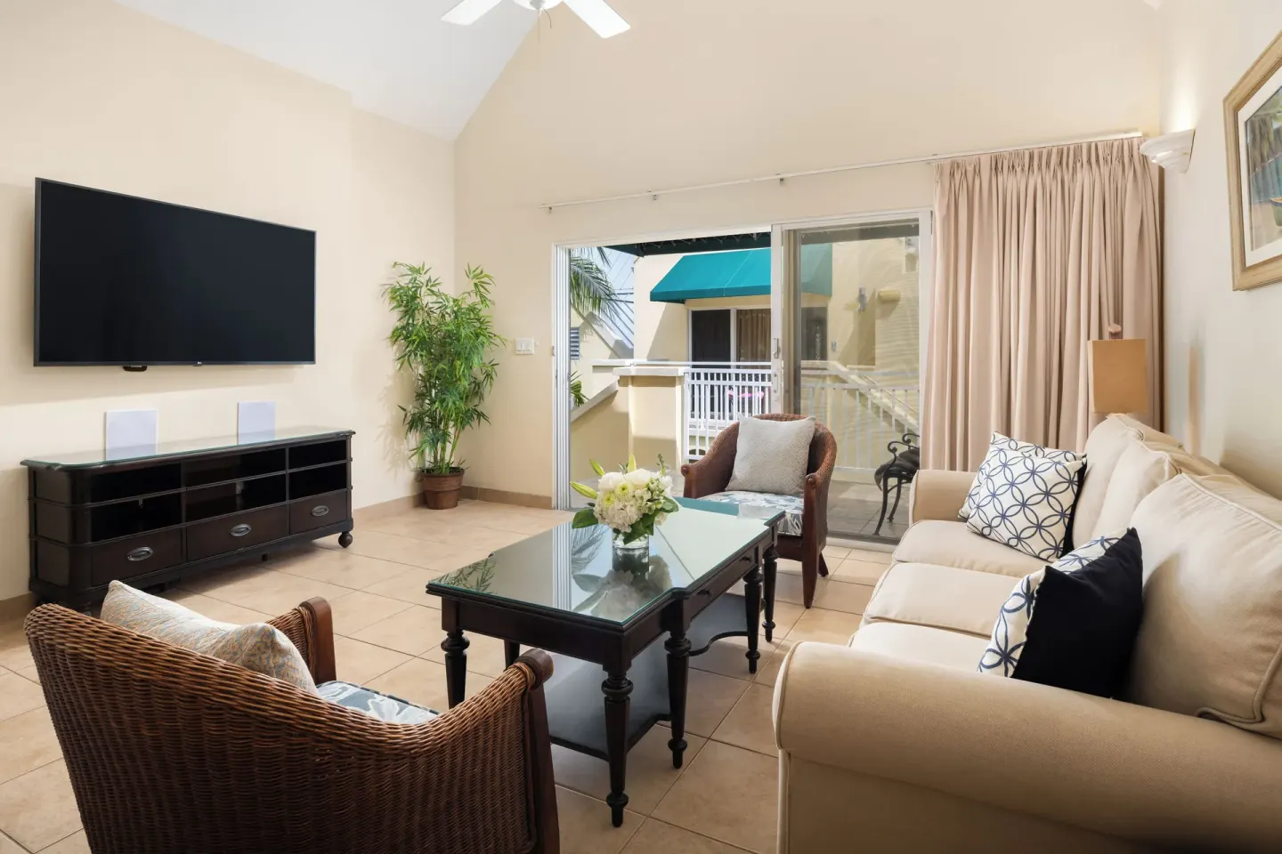 Living area with sofa, TV, and balcony access in a Bungalow 1 Bedroom at Windsong on the Reef.