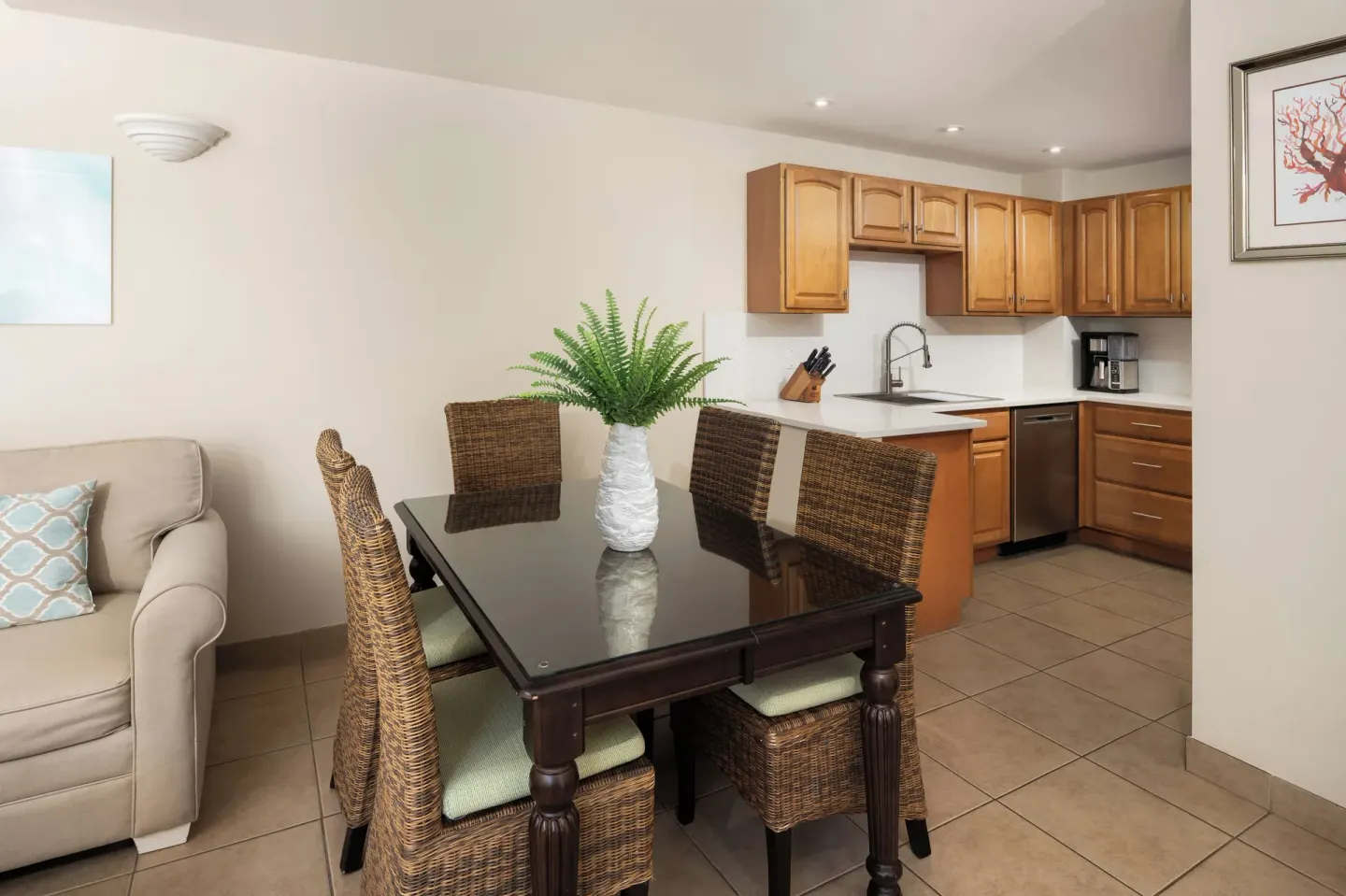Bungalow dining area and kitchen with wicker chairs at Windsong on the Reef.