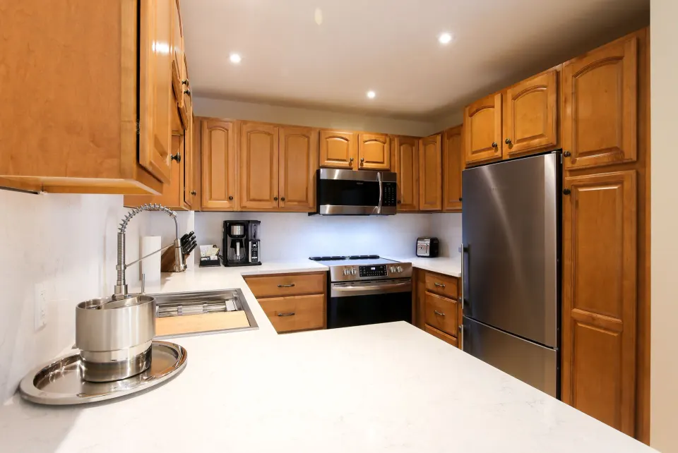 Bungalow kitchen with wood cabinets and stainless appliances at Windsong on the Reef.