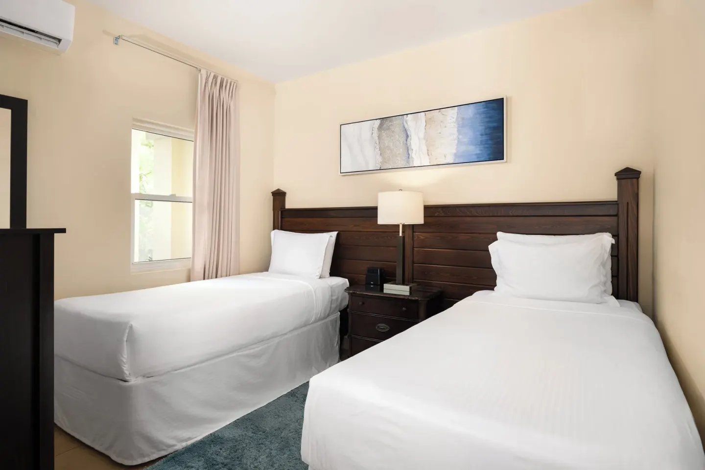 Bungalow twin bedroom with two beds and dark wood headboard at Windsong on the Reef.