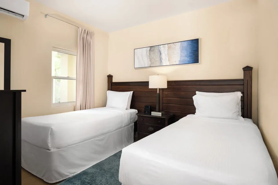 Bungalow twin bedroom with two beds and dark wood headboard at Windsong on the Reef.