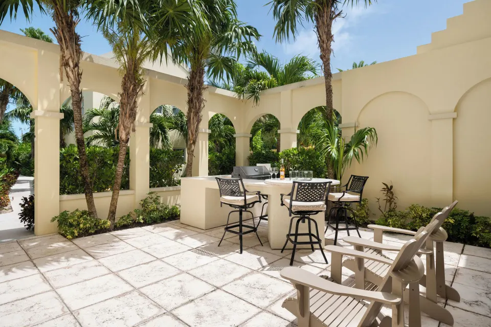Two-bedroom bungalow lanai with grill and seating at Windsong on the Reef.