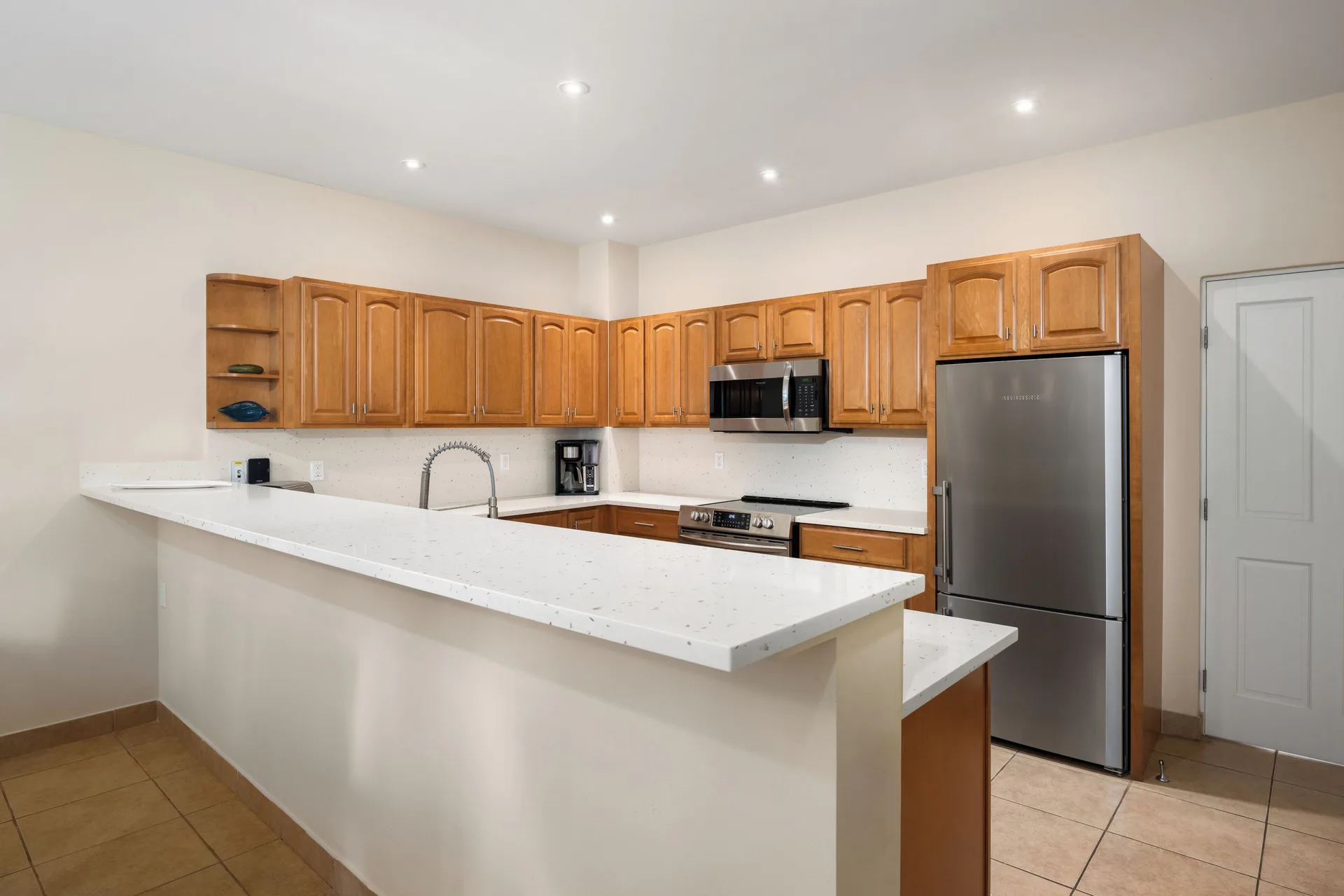 Bungalow kitchen with wood cabinets and stainless appliances at Windsong on the Reef.