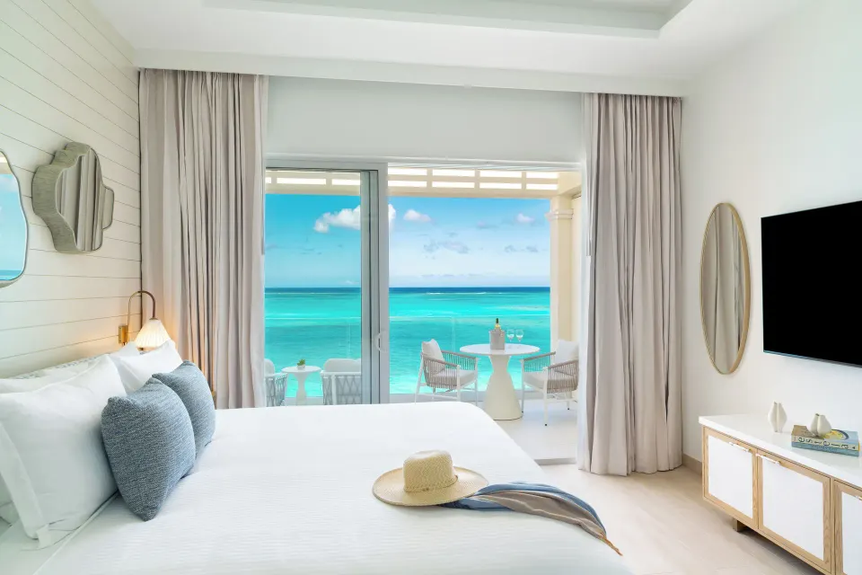 Junior Suite king bedroom with balcony and ocean view at Windsong on the Reef.