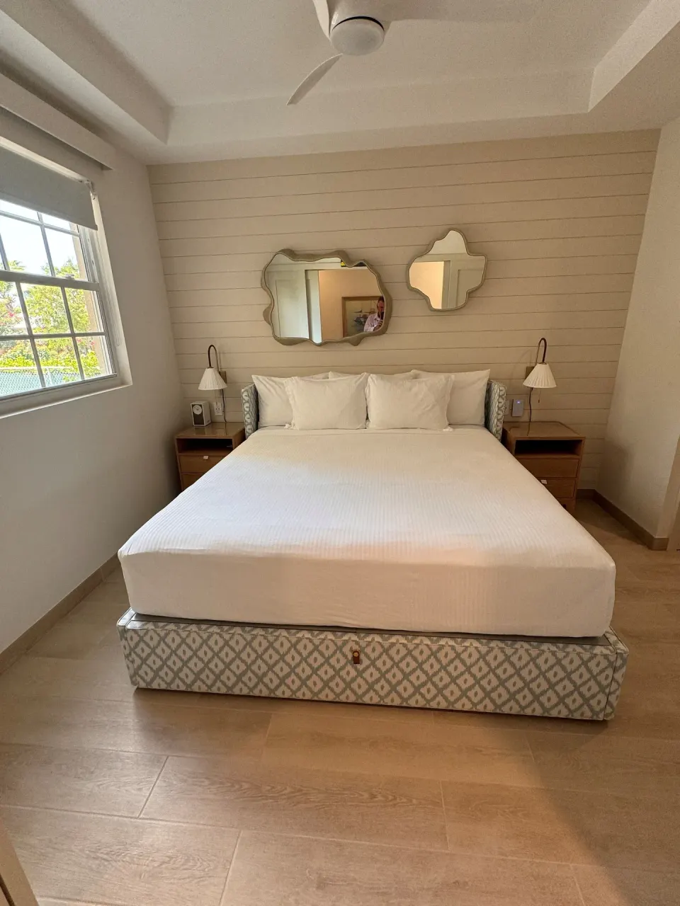 Junior Suite bedroom with king bed and wall mirrors at Windsong on the Reef.