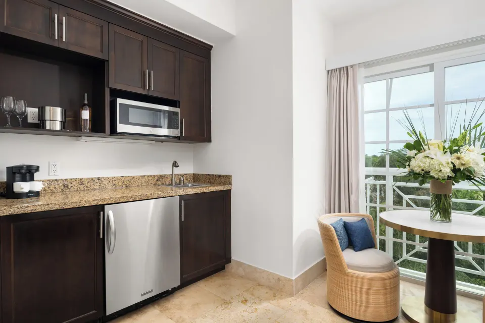 Studio kitchenette with balcony table and chair at Windsong on the Reef.