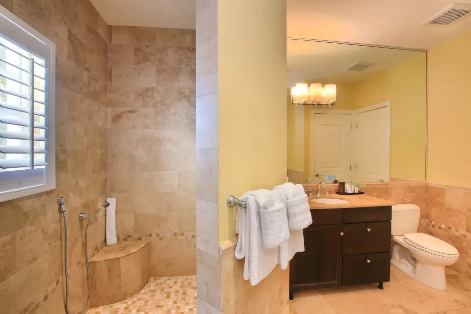 One Bedroom Suite bathroom with tiled walk-in shower and vanity at Windsong on the Reef.