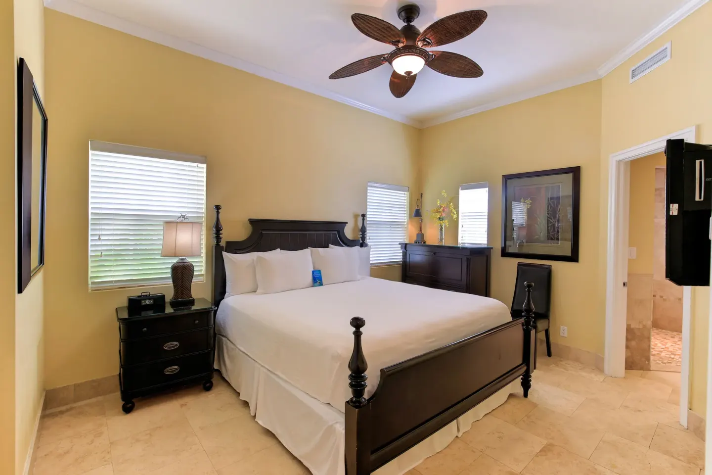One Bedroom Suite king bedroom with dark wood bed and dresser at Windsong on the Reef.