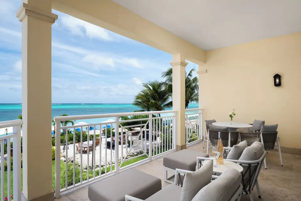 Oceanfront suite balcony with lounge seating and turquoise sea view at Windsong on the Reef.